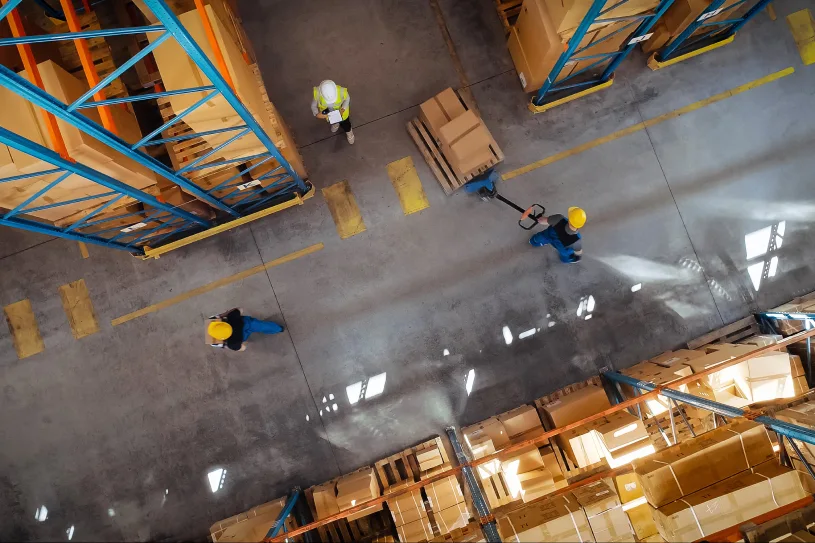 Aerial view of warehouse floor as facility workers transport products.
